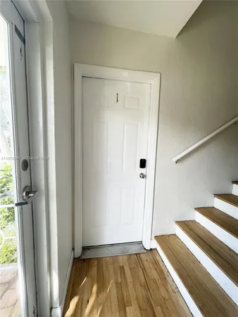 a view of a hallway with wooden floor and staircase