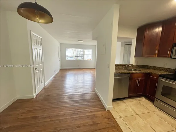 a kitchen with granite countertop a stove and a wooden floor