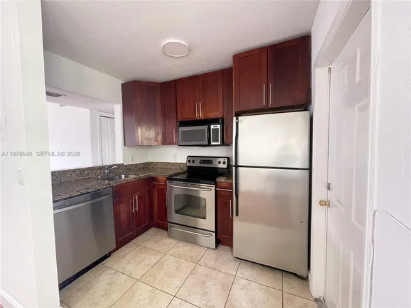 a kitchen with stainless steel appliances granite countertop a refrigerator stove a sink and dishwasher