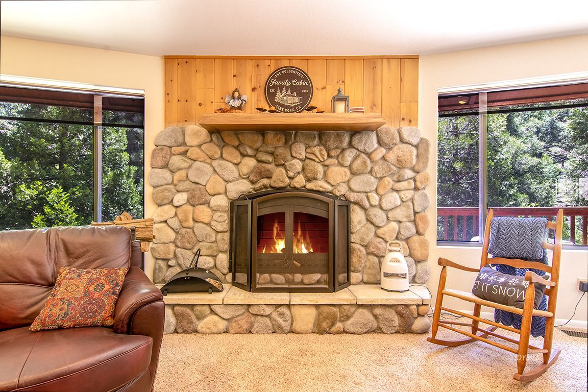 24625 Baldy Road Idyllwild, CA 92549 - Photo 10 of 80 a living room with furniture a fireplace and a floor to ceiling window