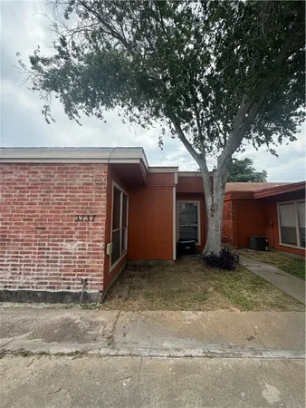 a view of a house with a large tree and a garage