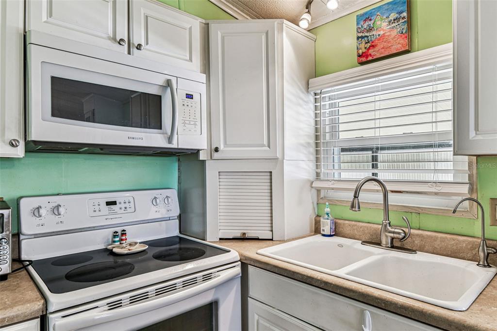 12501 Ulmerton Road, Unit 71 Largo, FL 33774 - Photo 13 of 75 a kitchen with a stove and a microwave