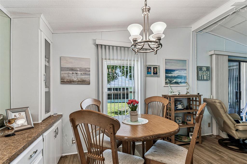 12501 Ulmerton Road, Unit 71 Largo, FL 33774 - Photo 17 of 75 a view of a dining room with furniture a chandelier and wooden floor