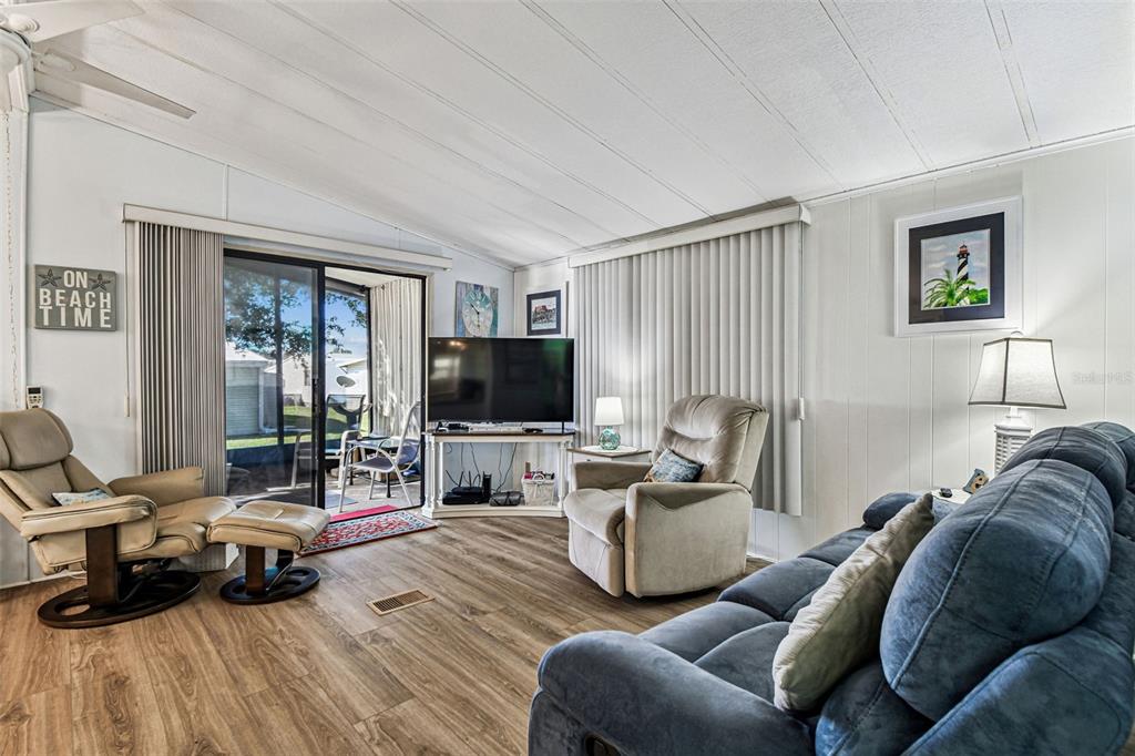 12501 Ulmerton Road, Unit 71 Largo, FL 33774 - Photo 18 of 75 a living room with furniture a flat screen tv and a large window
