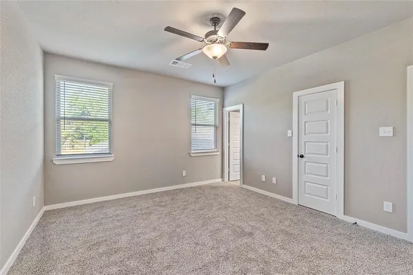 a view of an empty room with a ceiling fan and a window