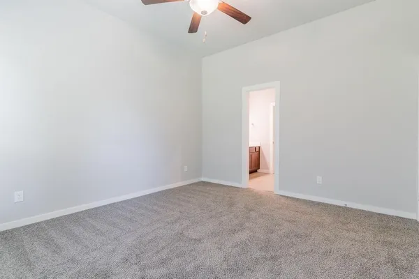 an empty room with a ceiling fan and a window