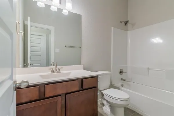 a bathroom with a sink a toilet a mirror and shower