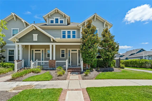 a front view of a house with a yard and potted plants