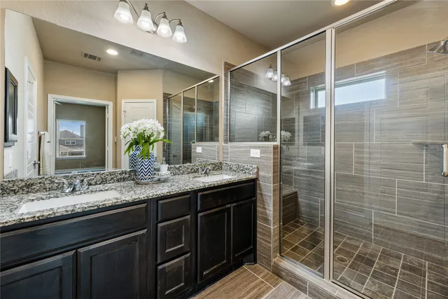 a bathroom with a shower sink and mirror