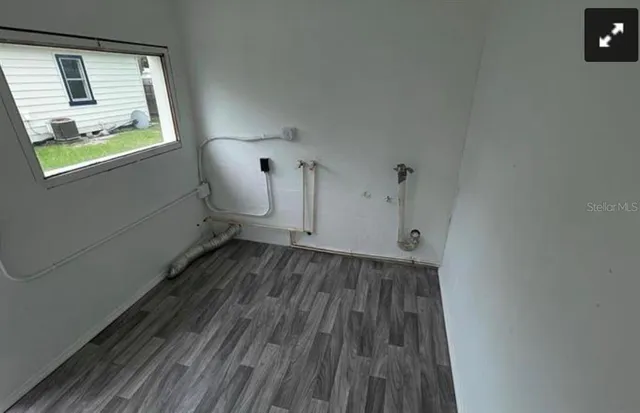 a view of a hallway with wooden floor and a window