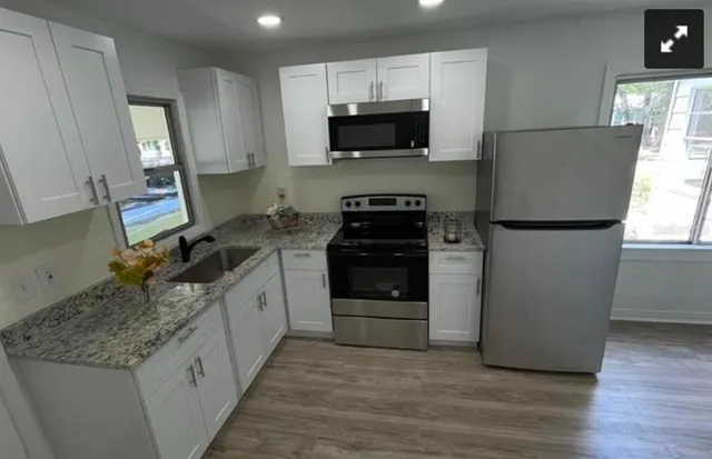 a kitchen with a sink a stove and a microwave