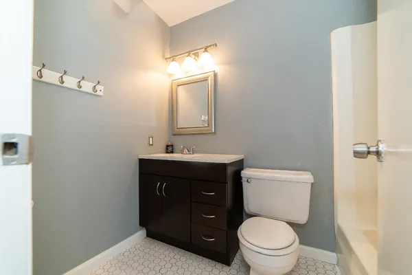 a bathroom with a toilet a sink and mirror