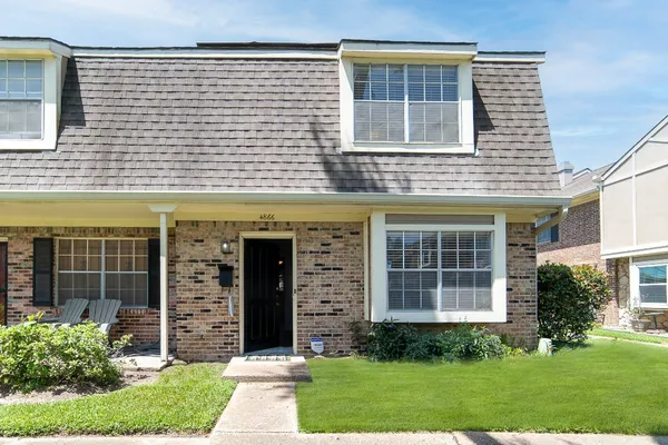 front view of a brick house with a yard