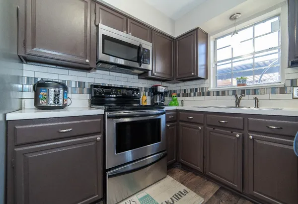 a kitchen with stainless steel appliances granite countertop a stove microwave and sink