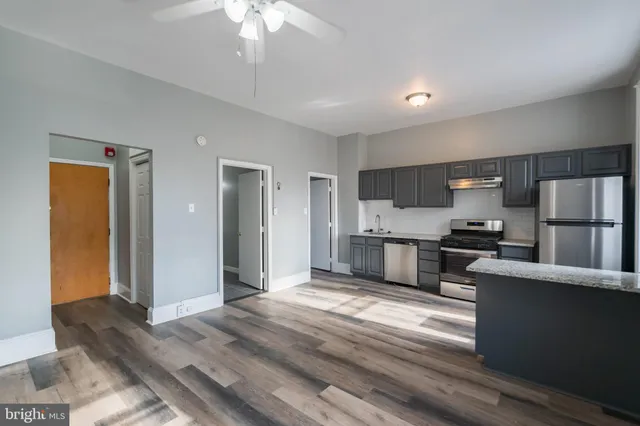 a kitchen with stainless steel appliances kitchen island granite countertop a refrigerator stove and oven