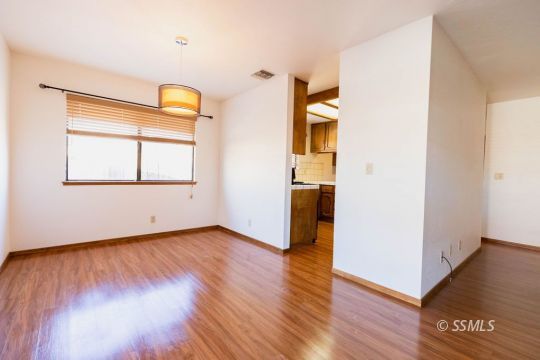 321 South Locust Street Ridgecrest, CA 93555 - Photo 8 of 30 an empty room with wooden floor and a window