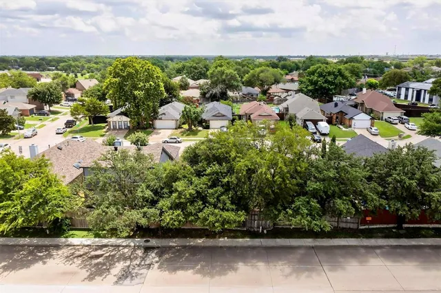 an aerial view of residential houses with outdoor space and parking