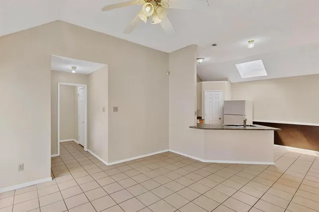 an empty room with windows and fireplace