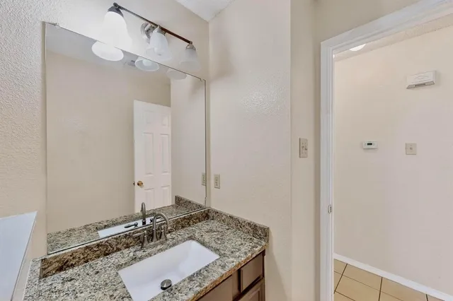 an empty room with a chandelier fan and glass door