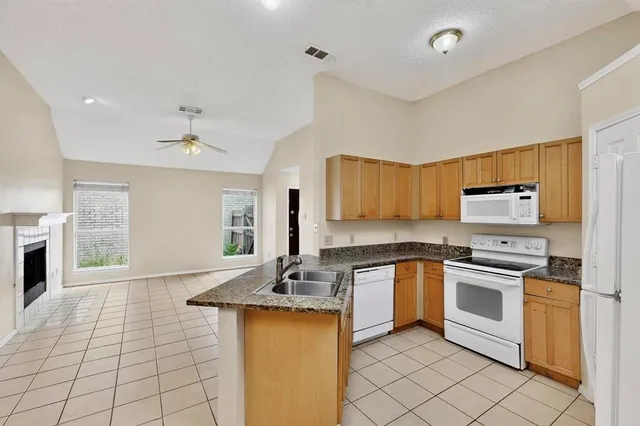 an aerial view of residential houses with outdoor space and trees