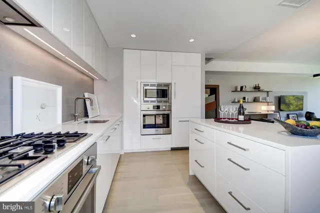 a kitchen with stainless steel appliances a sink stove and cabinets