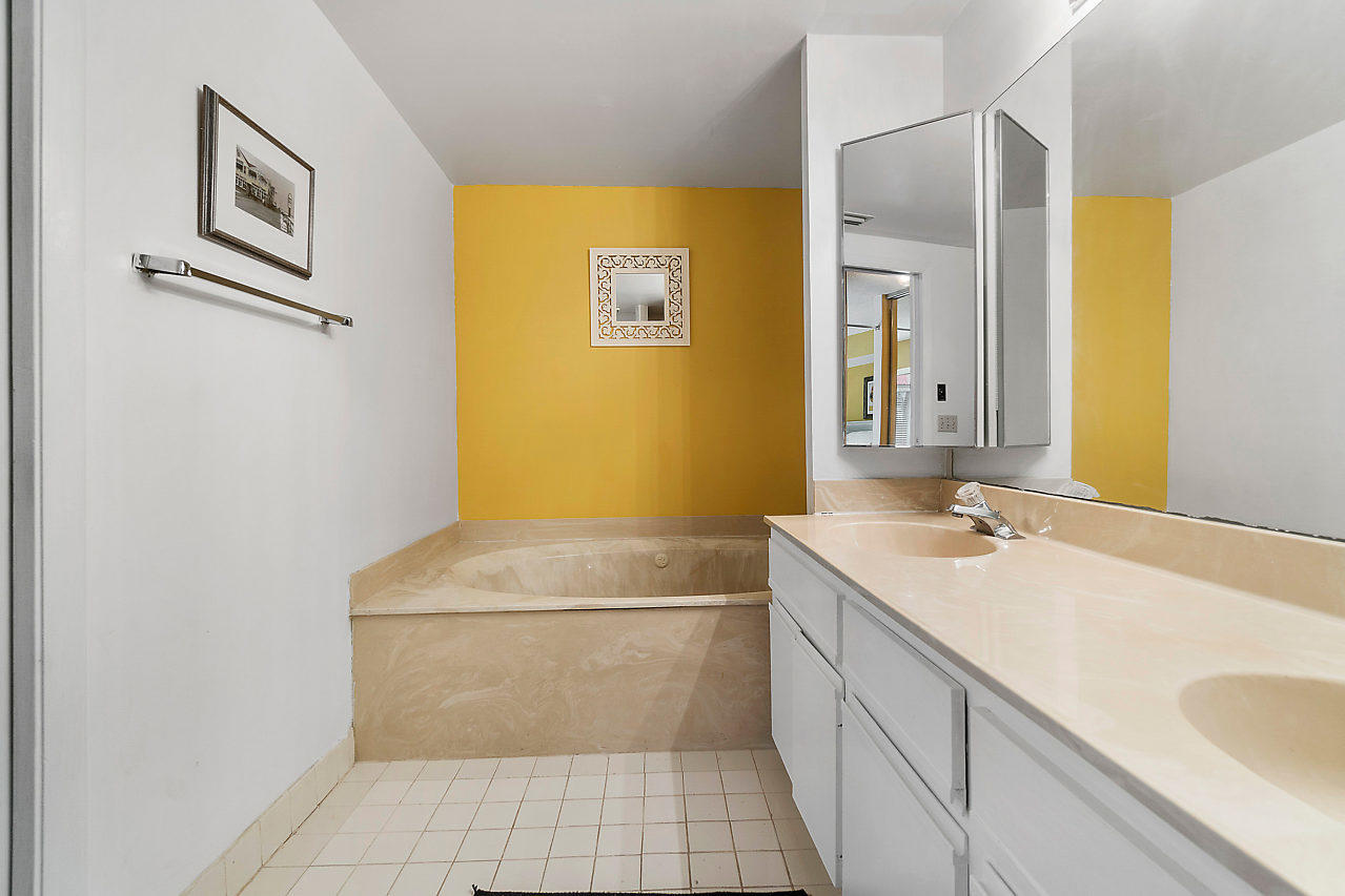 8481 Boca Rio Drive Boca Raton, FL 33433 - Photo 19 of 27 a bathroom with a granite countertop sink a mirror and a bathtub