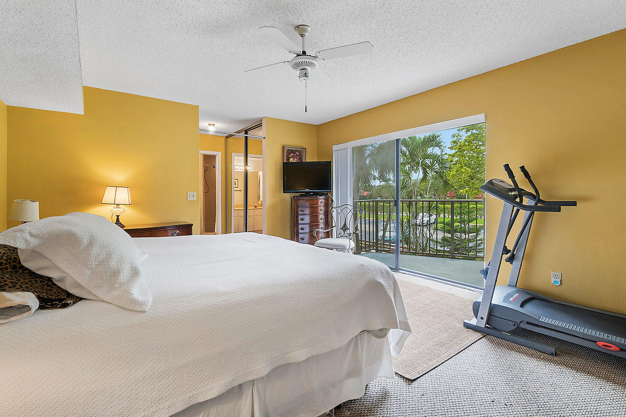 8481 Boca Rio Drive Boca Raton, FL 33433 - Photo 22 of 27 a bedroom with a bed and a chandelier