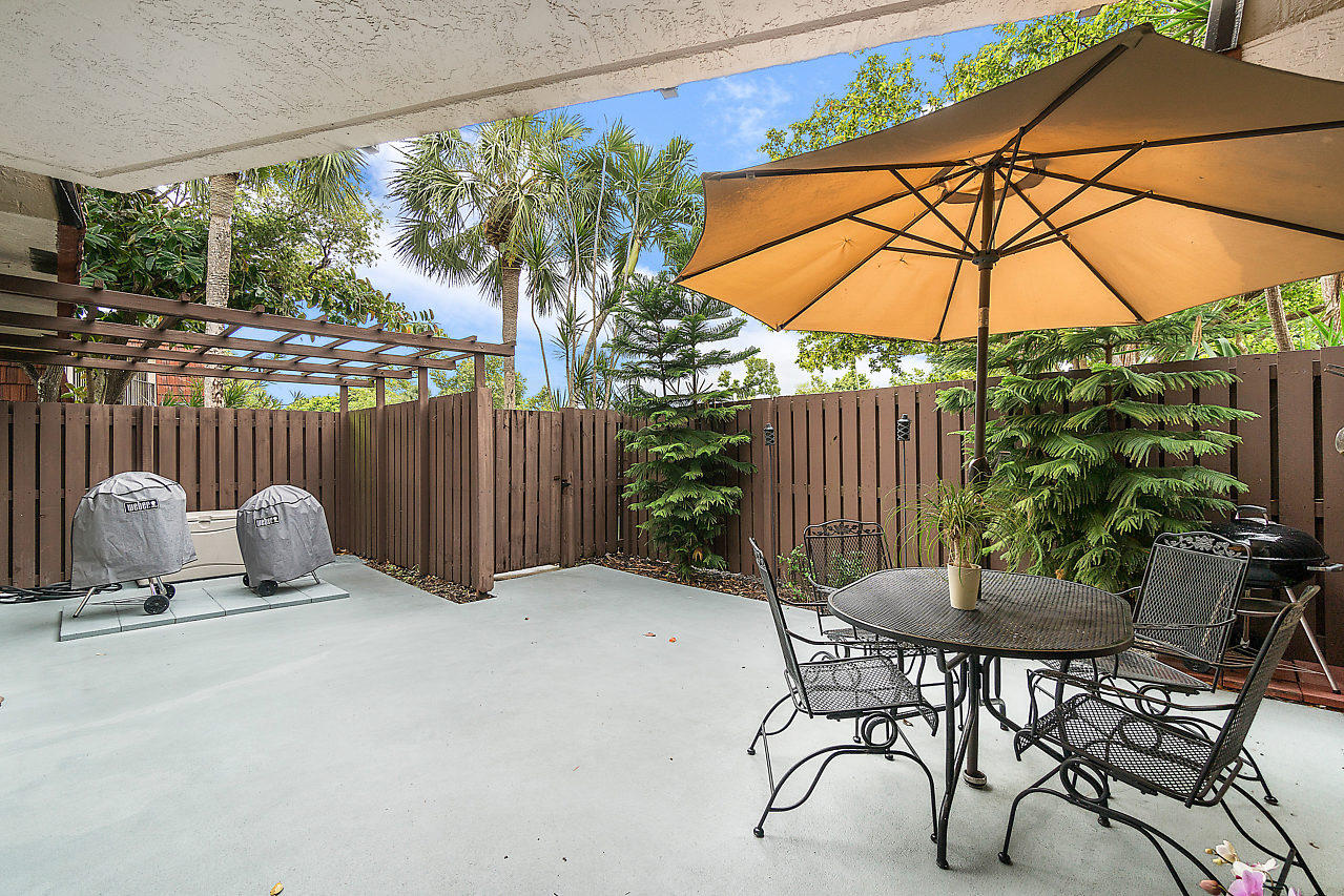 8481 Boca Rio Drive Boca Raton, FL 33433 - Photo 5 of 27 a view of patio with a table and chairs under an umbrella