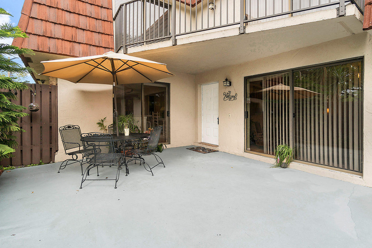 8481 Boca Rio Drive Boca Raton, FL 33433 - Photo 7 of 27 a view of a patio with table and chairs under an umbrella