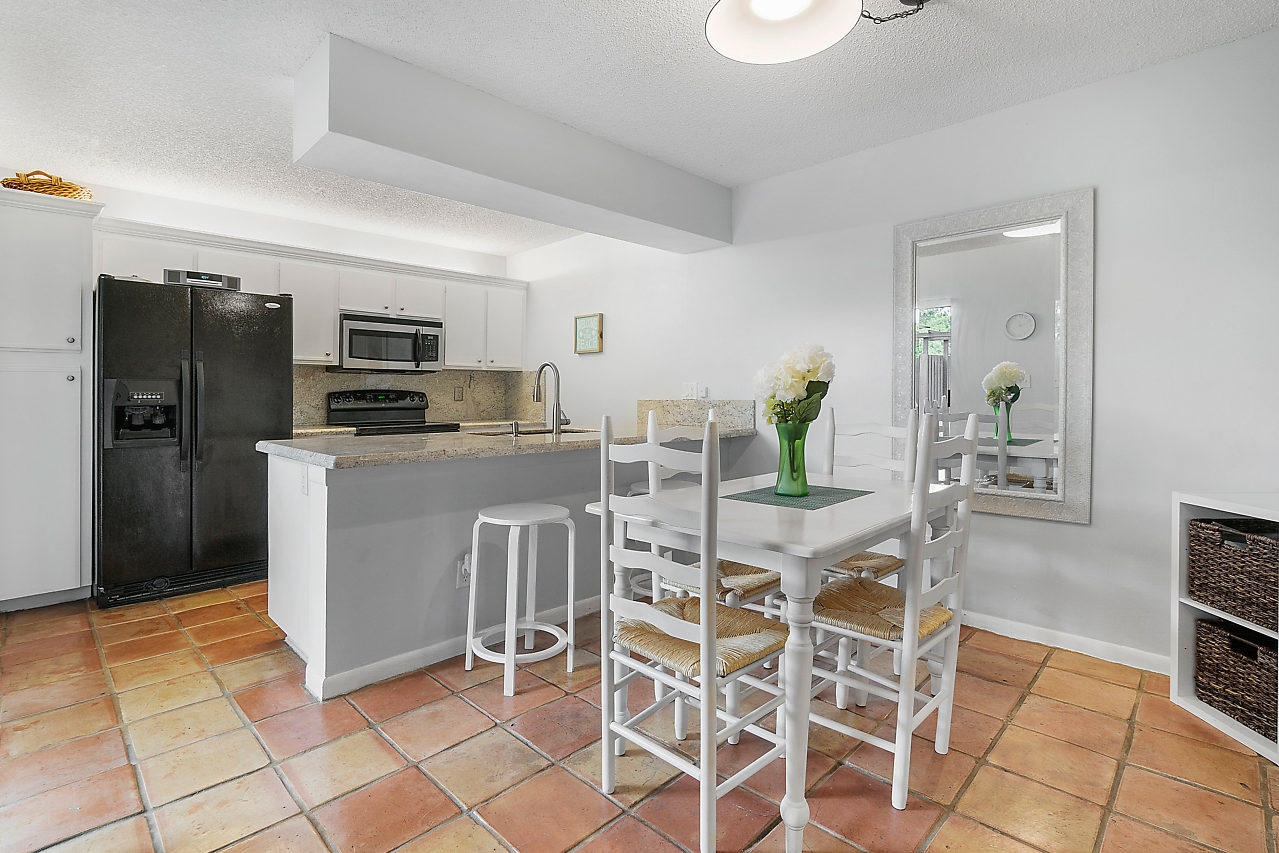 8481 Boca Rio Drive Boca Raton, FL 33433 - Photo 10 of 27 a kitchen with stainless steel appliances kitchen island granite countertop dining table chair and a refrigerator