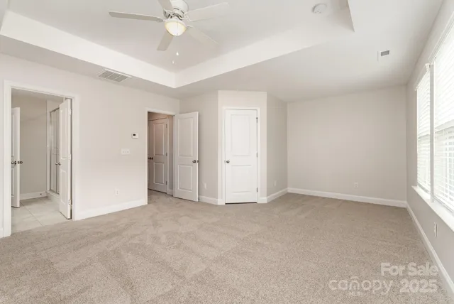 an empty room with fan and windows