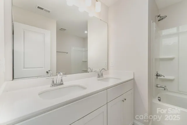 a bathroom with a sink double vanity granite tub and shower
