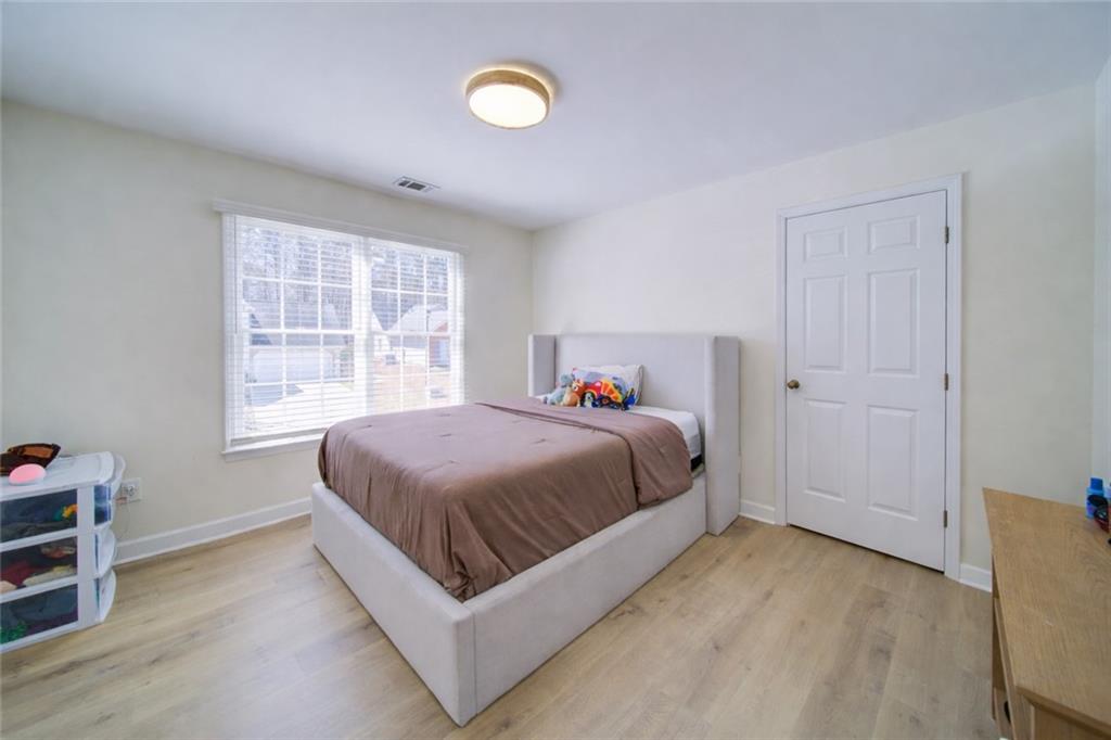745 Welford Road Northwest Suwanee, GA 30024 - Photo 18 of 32 a spacious bedroom with a bed and a window