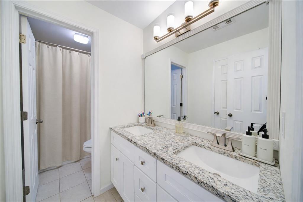 745 Welford Road Northwest Suwanee, GA 30024 - Photo 19 of 32 a bathroom with a granite countertop sink and a mirror