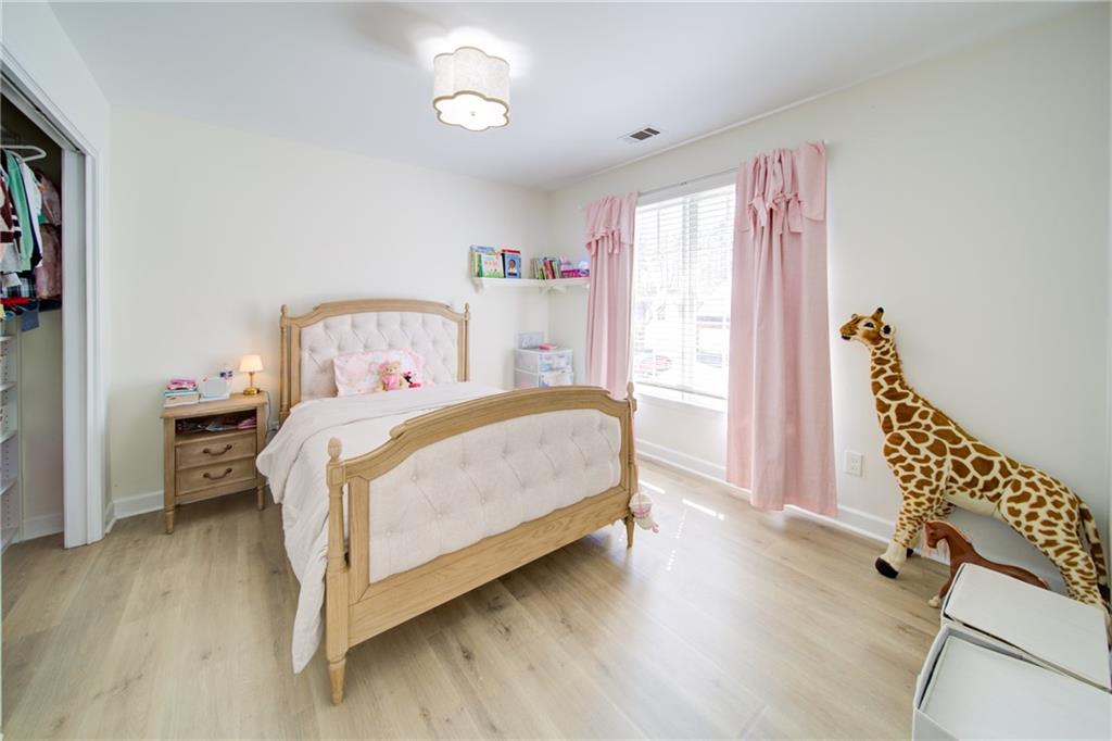 745 Welford Road Northwest Suwanee, GA 30024 - Photo 20 of 32 a bedroom with a bed and a chair