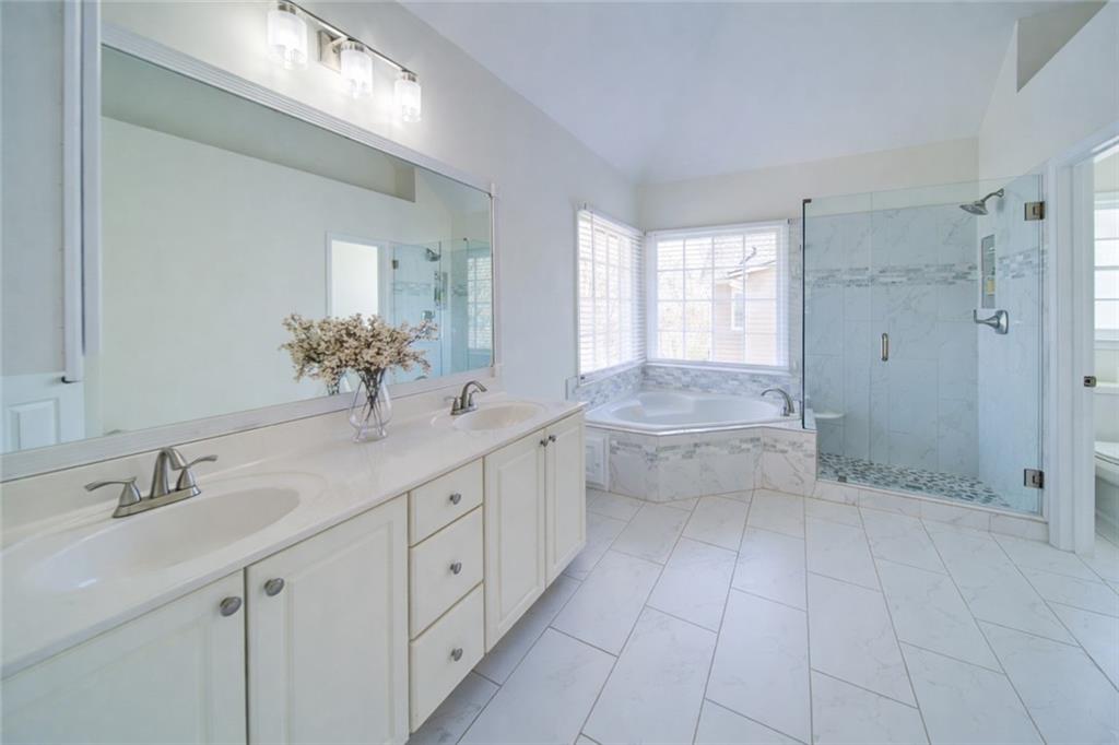 745 Welford Road Northwest Suwanee, GA 30024 - Photo 22 of 32 a spacious bathroom with a shower sink and mirror
