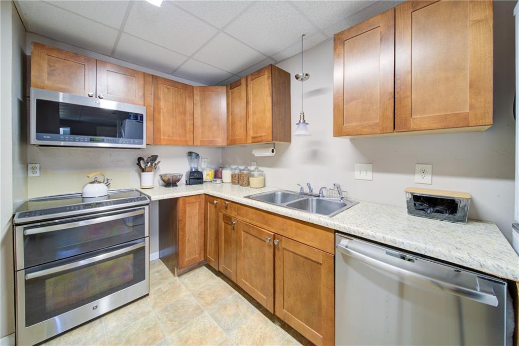 745 Welford Road Northwest Suwanee, GA 30024 - Photo 28 of 32 a kitchen with stainless steel appliances granite countertop a sink a stove and cabinets