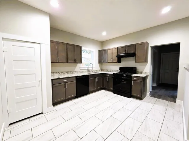 a kitchen with stainless steel appliances kitchen island granite countertop a refrigerator and a sink