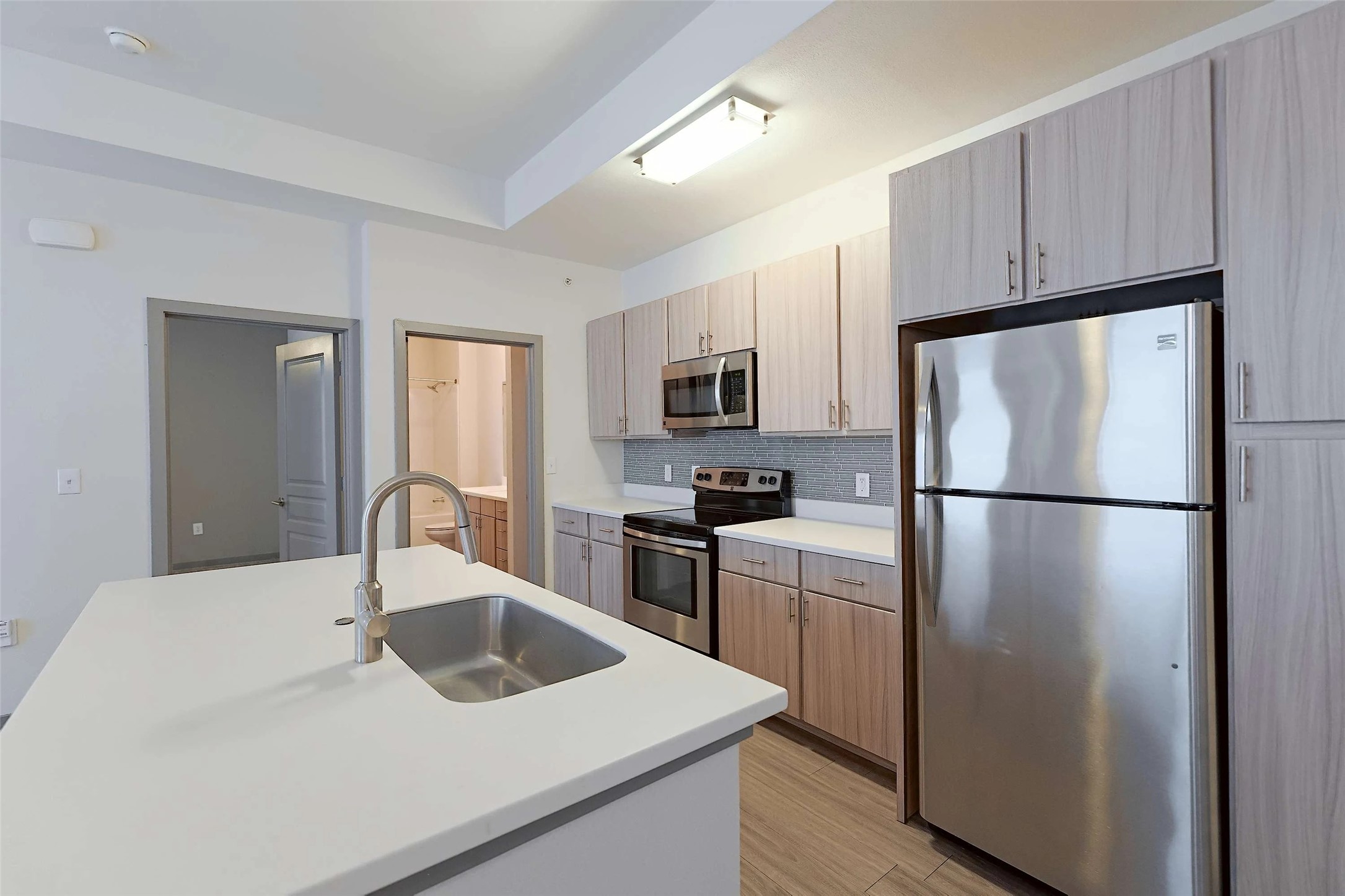 8515 Interstate 35, Unit 1206 Austin, TX 78744 - Photo 10 of 20 a kitchen with a sink a refrigerator a microwave and cabinets