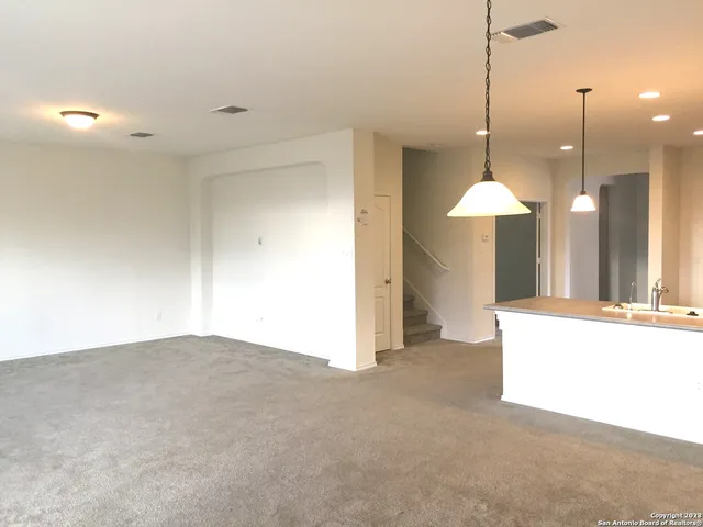 a view of a kitchen with a sink and a chandelier fan