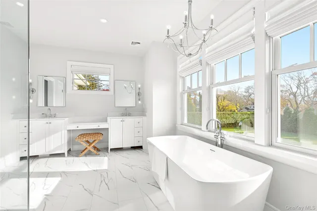 a spacious bathroom with a tub sink and mirror
