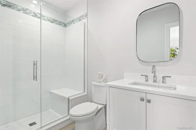 a bathroom with a toilet sink vanity and mirror