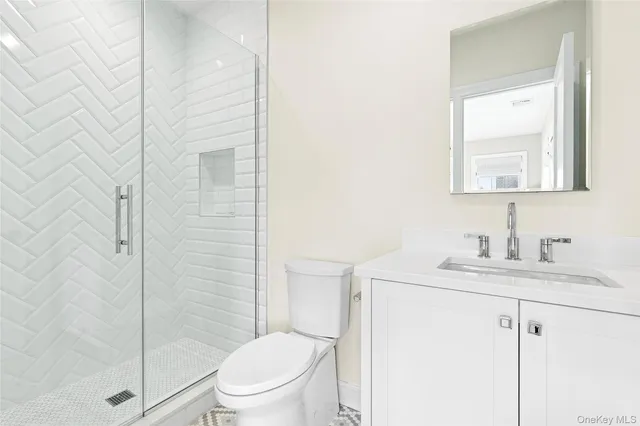 a bathroom with a granite countertop sink toilet a mirror and shower