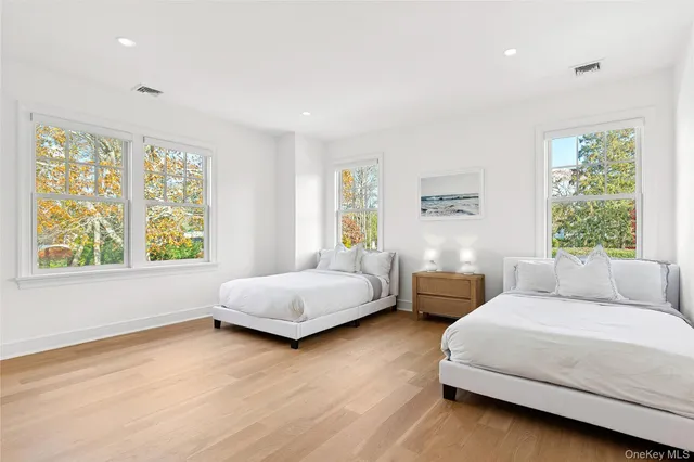 a bedroom with two beds and a large window