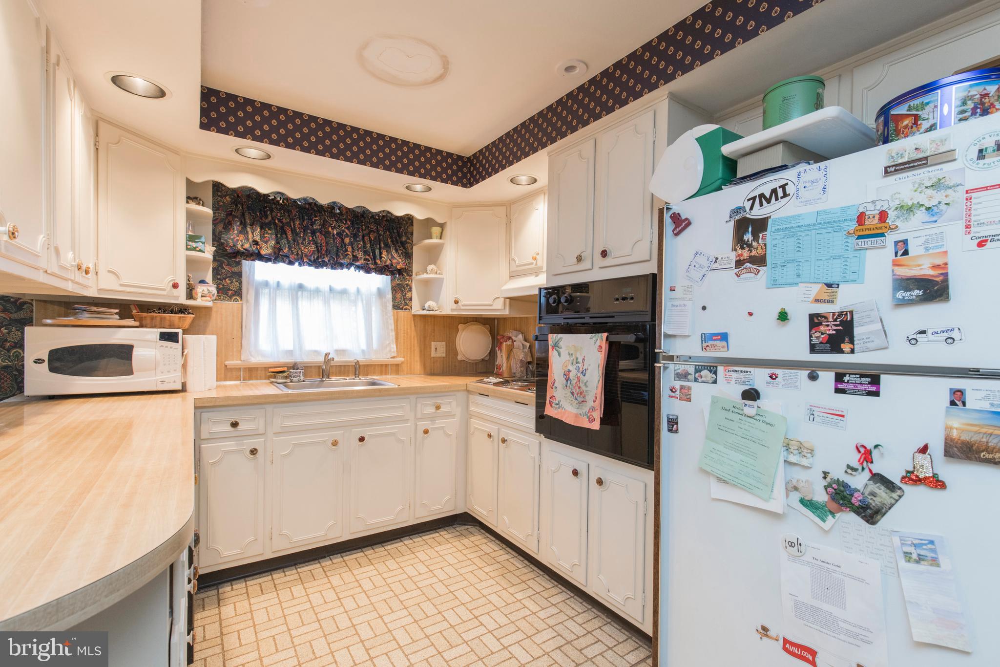244 Shawnee Road Ardmore, PA 19003 - Photo 12 of 30 a kitchen with refrigerator a sink a stove and white cabinets