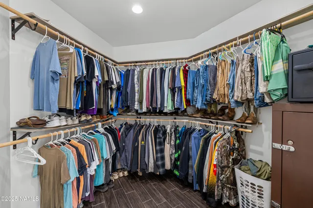 a view of walk in closet with clothes and shoes