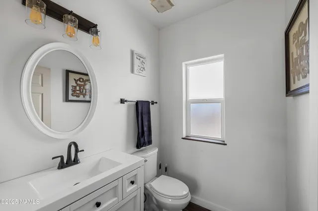 a bathroom with a toilet a sink and mirror
