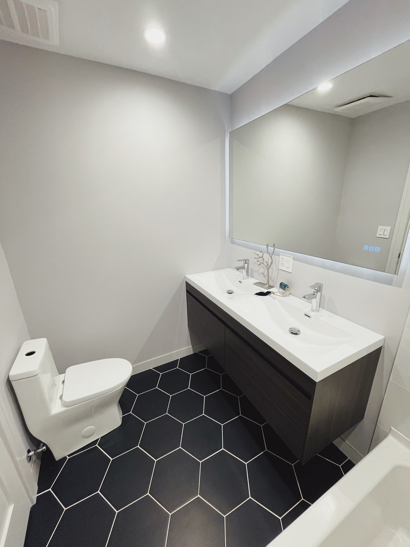 1017 Dell Road Northbrook, IL 60062 - Photo 31 of 52 a bathroom with a sink a toilet and a mirror