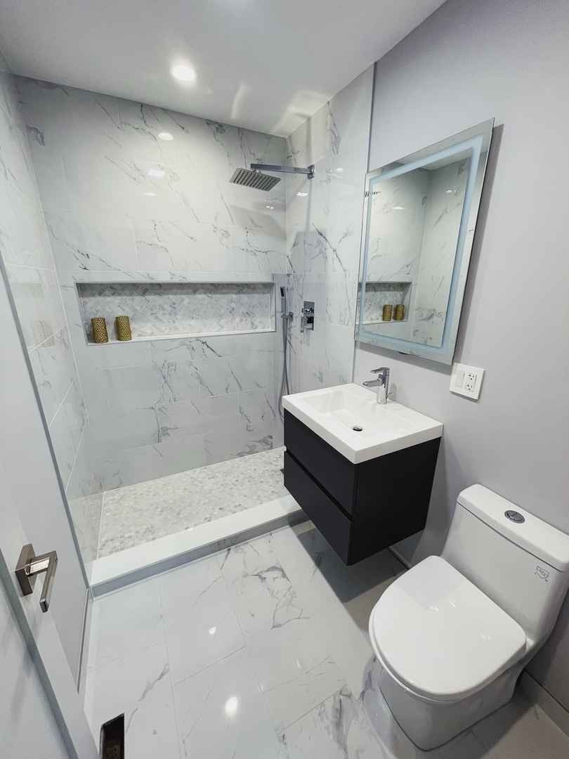 1017 Dell Road Northbrook, IL 60062 - Photo 34 of 52 a bathroom with a sink toilet a mirror and shower