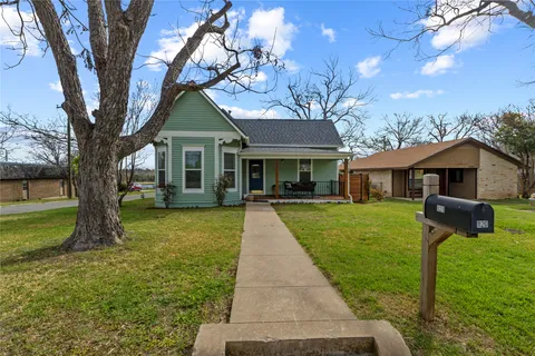 a front view of a house with yard and green space